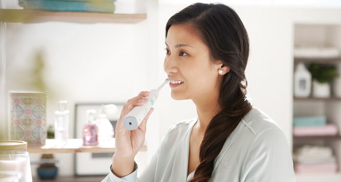 Mujer cepillo eléctrico dientes